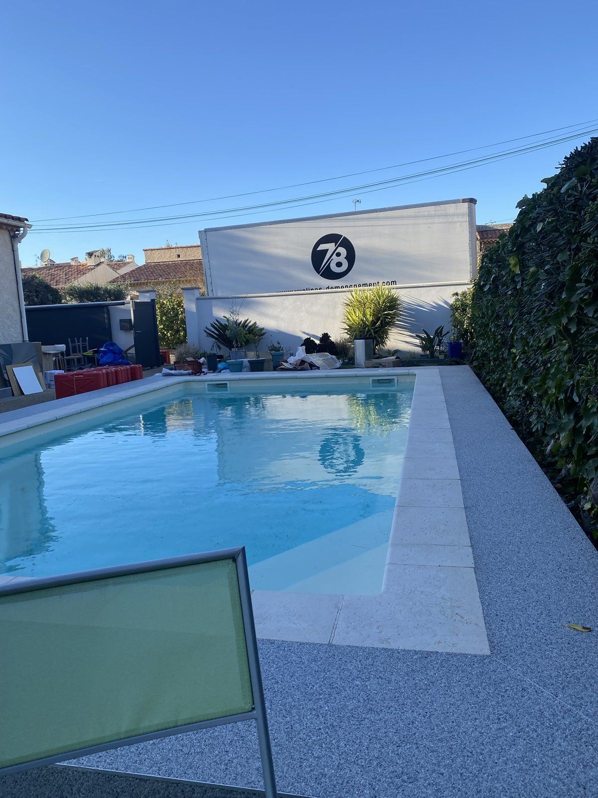 Camion Yvelines Group derrière une villa avec piscine
