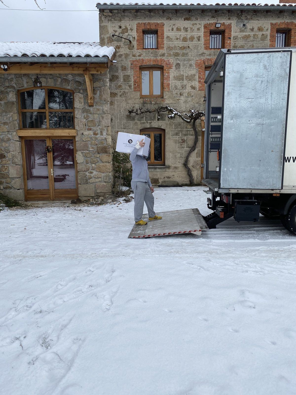 Déménageur portant un carton vers le camion sous la neige