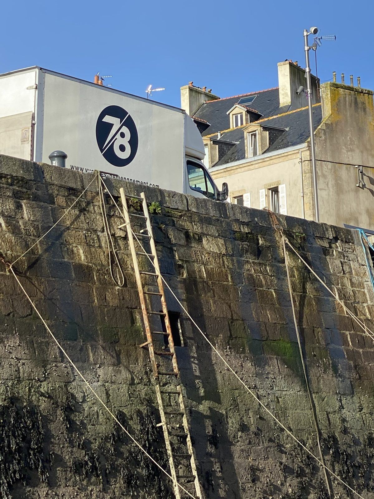 Camion Yvelines Group garé sur un quai en pierre