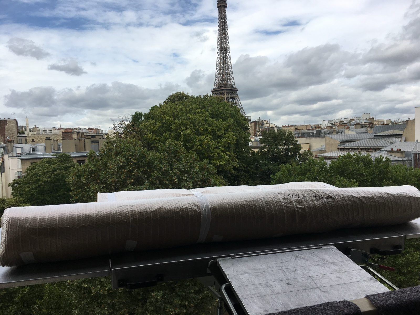 Tapis roulé et emballé sur le monte-meuble face à la tour Eiffel
