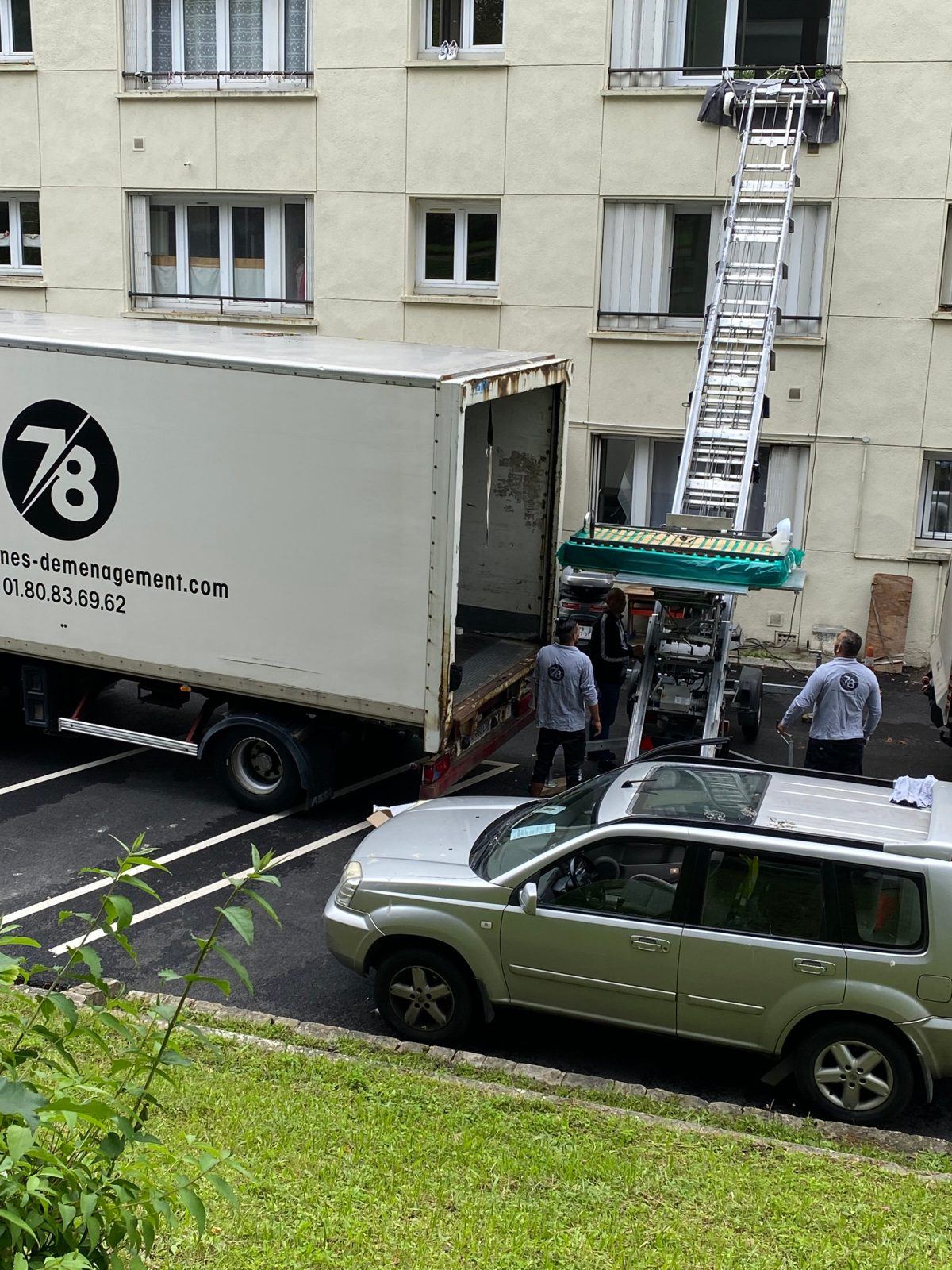 Monte-meuble descendant un lit le long d'une façade